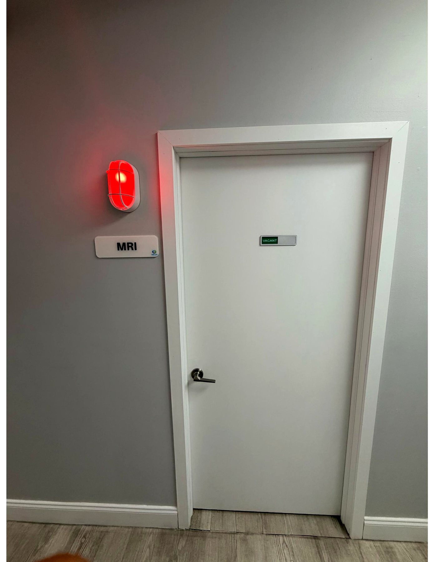 The MRI suite door in the hallway with its illuminated red scanner-in-use light