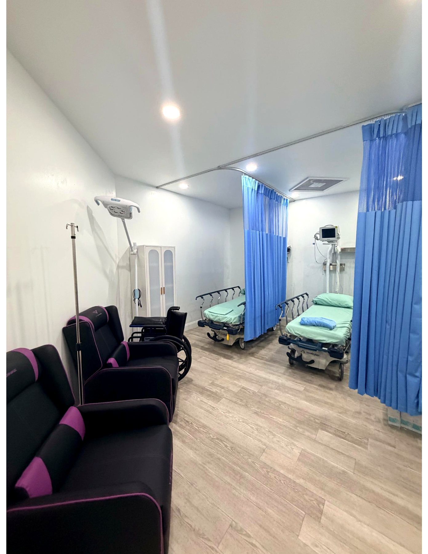 The recovery suite with curtained stretcher bays, patient monitor and recliners